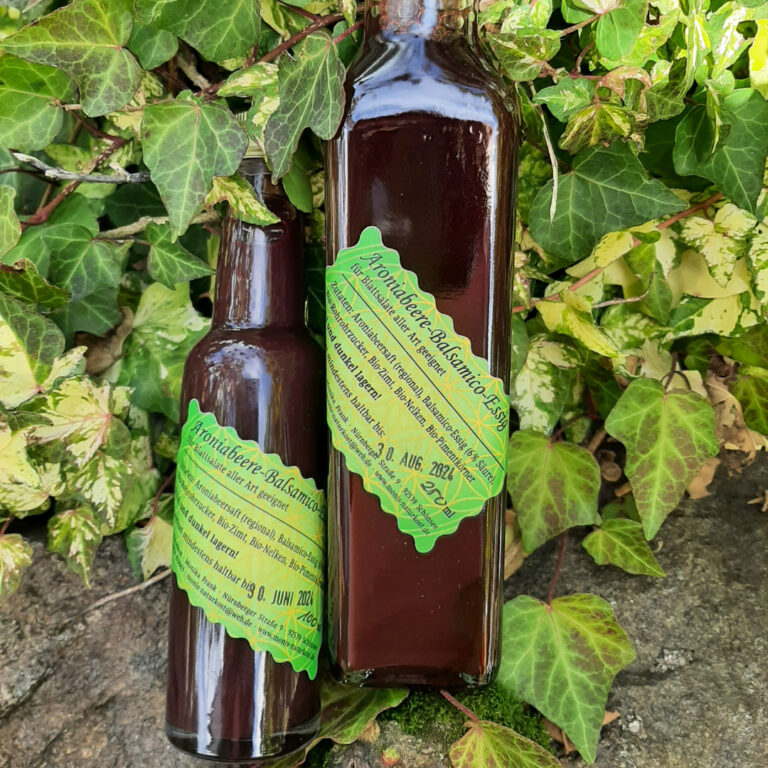 Balsamicoessig in Glasflasche auf Efeublätter
