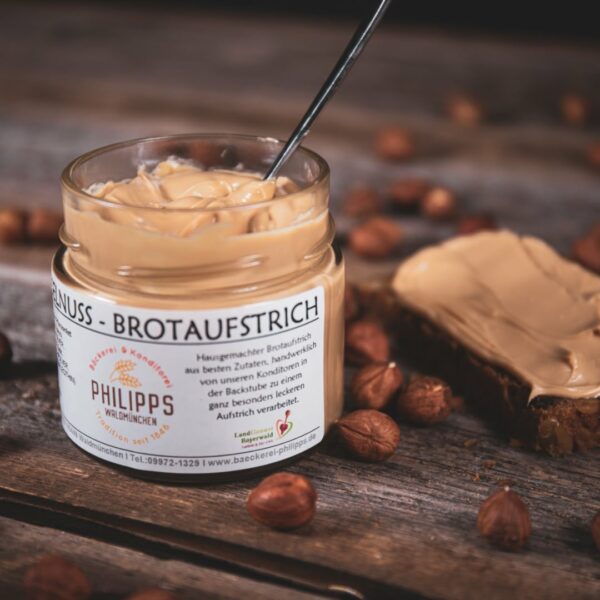 Haselnussaufstrich im Glas auf frischem Brot